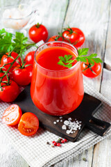  Glass of fresh tomato juice close up on the table, vertical photo