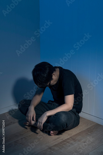 暗い部屋で床に座っている男性 Wall Mural Wallpaper Murals Kai