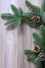 The wooden table is framed by fir branches with cones. Image with selective focus.