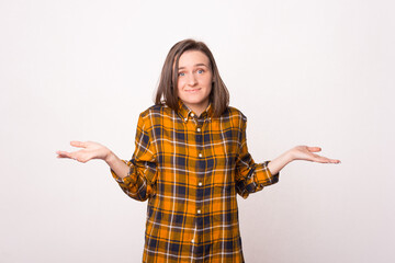 Unsure young woman is gesturing over white background
