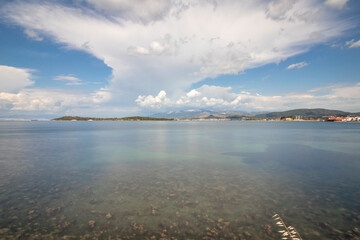 Long exposure view of Urla Quarantine Island from the shore, cloudy sky.