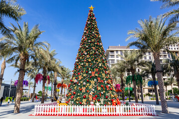Large Christmas Tree in Dubai, Town Square Park, 2020, amont green palm trees, christmas in arabic country.
