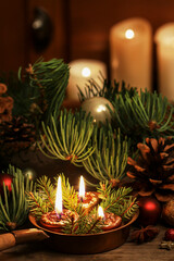 Christmas table decoration with candles and fir branches.