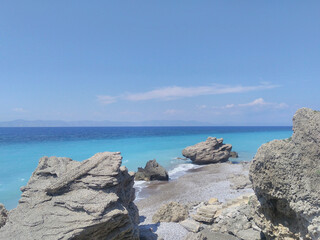 Fototapeta na wymiar Beautiful Aegean seascape: rocks on the beach, blue sea. Rhodes, Greece