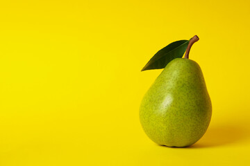 Fresh green pear on yellow background, space for text