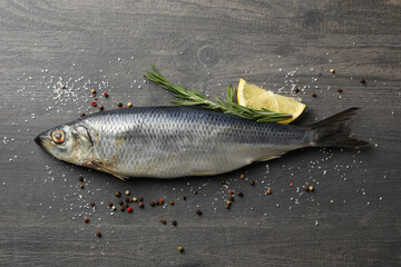 Herring fish and spices on gray wooden background