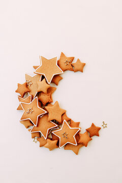 Christmas ginger cookies in the shape of stars. scattered cookies in the shape of a moon on a white background.