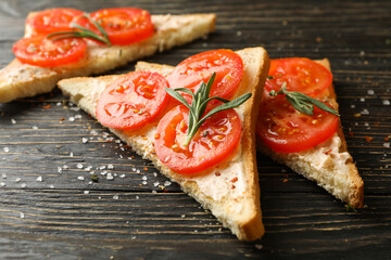 Concept of breakfast with toasts with tomato on wooden background