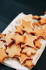 Winter ginger cookies in the shape of a star on a wooden board. Christmas set of cookies on a dark background.