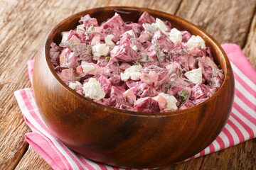 Salad of boiled beets, onions, garlic and feta dressed with yogurt close-up in a bowl on the table. horizontal
