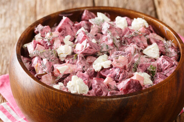 Delicious beetroot salad with feta dressed with yogurt close-up in a bowl on the table. horizontal