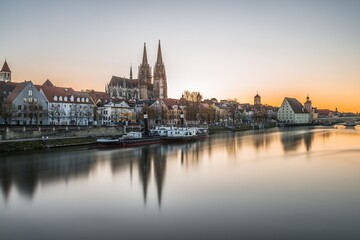 Berühmte Stadtansicht von Regensburg und Promenade mit steinerne Brücke dem Fluss Donau die historische Altstadt und der Dom Sankt Peter, Deutschland
