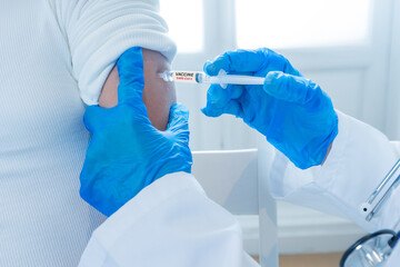 Doctor administrating COVID-19 Vaccine to a patient. First safe and effective coronavirus vaccine