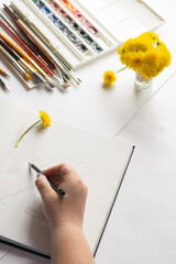 Woman artist draws with pencil makes outline for summer still life. Hobby art