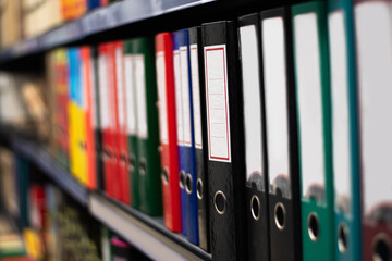 Paper binder shelf in a shop. Binder sale. Multicolor stationery folders.