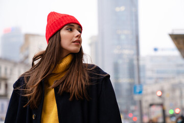Obraz premium Charming caucasian girl looking aside while posing at city street