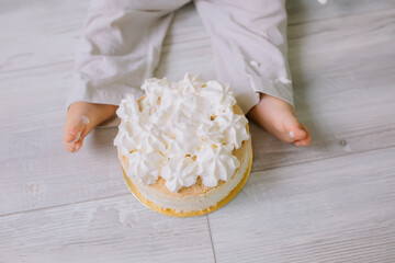 Child's feet on the floor near the cream cake