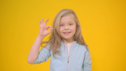 Little girl shows a sign okay with her fingers