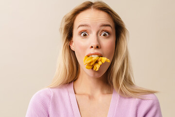Surprised beautiful girl posing with french fries in her mouth