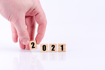 2021 als Jahreszahl von einer Hand gelegt auf weißen Hintergrund