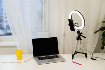 laptop, lamp and tripod on the table for online interview