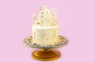 New Year's festive Christmas cake on a stand on a pink background. Christmas sweets decorated with New Year's decor and berries.