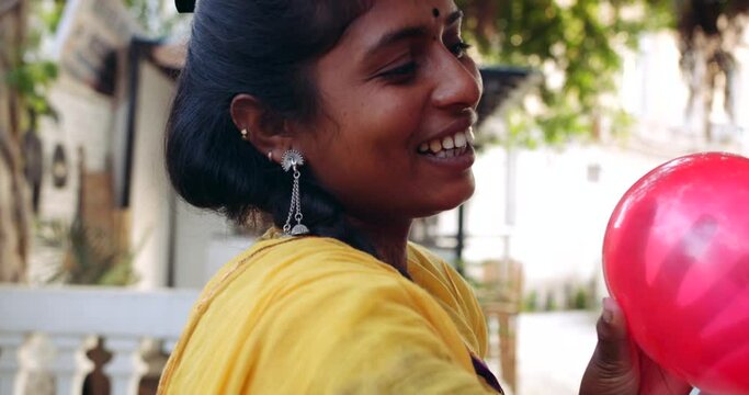 Slow-motion of pretty two girl friends women faces only like sisters playing fooling around smiling blowing vibrant balloons and playful naughty mischief positive energetic fun foreground
