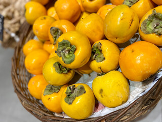 Ripe orange persimmon fruit for sale .fresh persimmon on bamboo basket