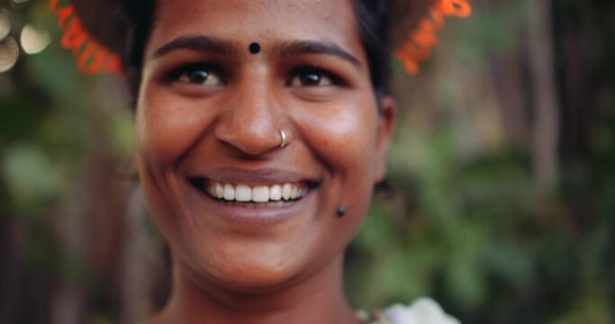 Slow-motion CU close-up of pretty face of a one young woman smiling wide with birthmark mole holding an orange balloons and wearing hat celebrating having fun happy positive emotion