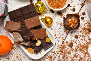 sweet food top view background for merry christmas or new year holiday decoration - chocolate candies, tangerines, cookies on white wood