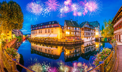 Fireworks at the old town water canal panorama of Strasbourg, Alsace, France. Traditional half timbered houses of Petite France - obrazy, fototapety, plakaty
