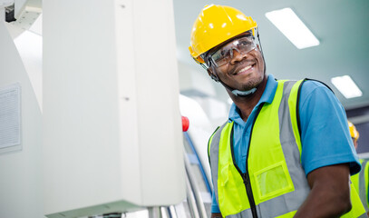Black African American worker man control with industry machine at industrial factory. technology invention manufacturing. career and professional skill. diversity people working together. copy space
