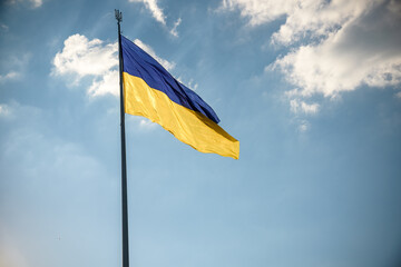 Ukrainian flag on top of hill. clear blue sky with clouds