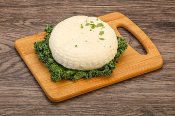 Caucasian suluguni round cheese piece