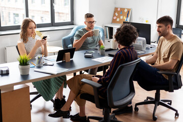 Fototapeta premium business, people and corporate concept - team of startuppers drinking coffee at office