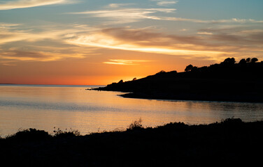 High contrast landscape at sunset with still ocean and a colourful sky