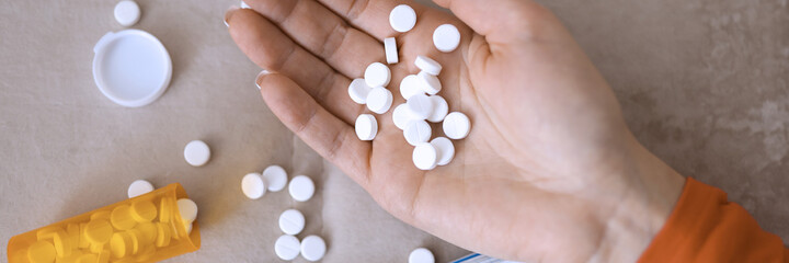 Womans hand with pills lying on couch with death note close-up. Increase in number of suicides concept