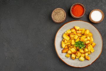 top view tasty fried potatoes inside plate with seasonings on dark background photo food oil color dinner bread free space