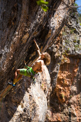A young athlete climbs a rock