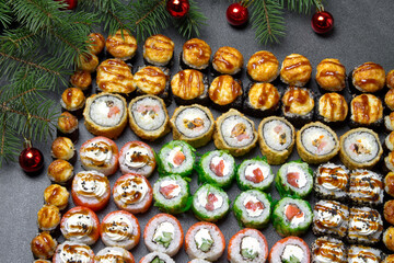 Sushi on christmas background. Christmas tree with toys and sushi rolls set for menu and advertising. Christmas pattern with food