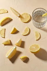 drink, detox and vitaminic concept - glass of water and lemon slices on table