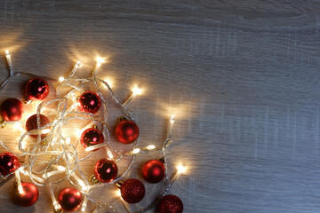 New Year template with red shiny, matte and sparkling christmas balls and garland of yellow led lights with copy space
