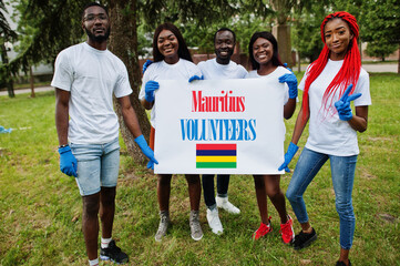 Group of happy african volunteers hold blank with Mauritius flag in park. Africa countries...