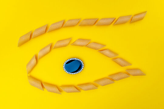 group of pasta lined up in the shape of an eye with a jewel in the center