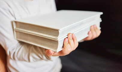 Frau tr&auml;gt einen Stapel B&uuml;cher zum Ausleihen