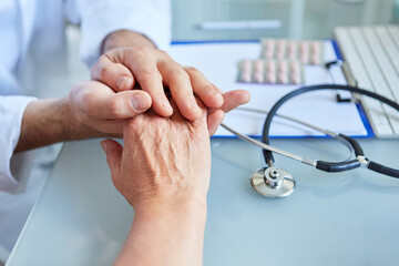 Hausarzt hält die Hand eines Patienten