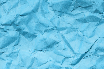 Blue crumpled paper texture. Creades piece of paper background. Wrinkled color paper pattern.