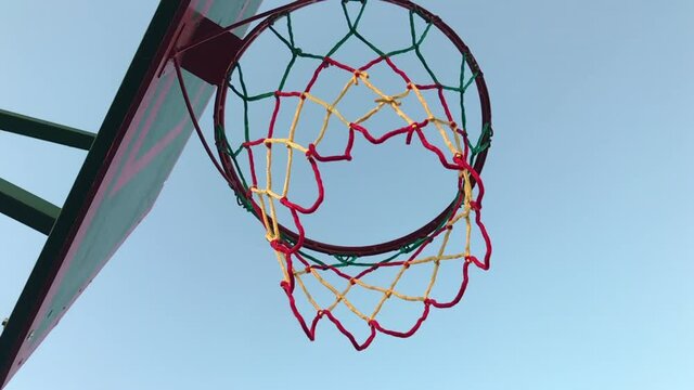 Basketball basket with a net against a blue sky in the street on the court for street basketball and streetball.