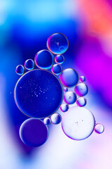 Oil droplets on water with colourfull pattern.