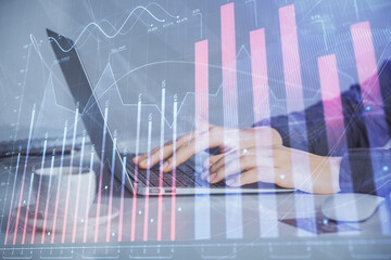 Double exposure of businesswoman hands typing on computer and forex graph hologram drawing....
